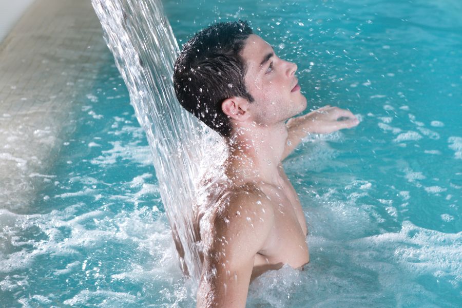 persona bajo cascada de piscina